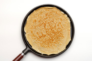 Frying a pancake cooking in a pan on the white