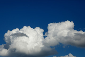 Naklejka na ściany i meble dark blue sky with bright white large clouds. close-up