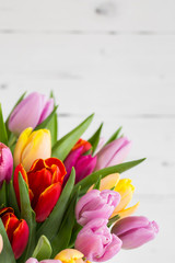 Beautiful bouquet of colorful tulips on a wooden background.