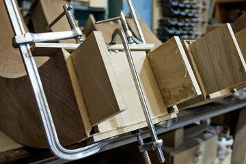 Clamped pieces of wood connecting with special clamp, wooden parts in the carpentry workshop