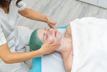 beautiful young woman with natural moisturizing mask on the face. Beauty treatment. Anti-aging skin...