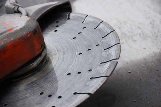 Concrete cutter machinery and cutting blade on a driveway