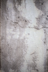 A cracked cement wall with peeling paint