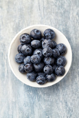 Bilberries on bright wooden background. Concept for healthy nutrition. Top view. 