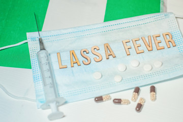 Nigerian flag under words Lassa fever outbreak concept. protective breathing mask and syringe....