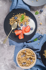 Ripe blueberries and strawberries with yogurt and granola