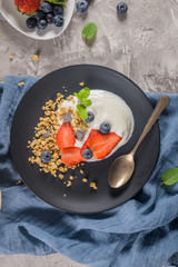 Ripe blueberries and strawberries with yogurt and granola