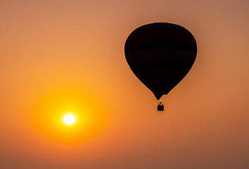 Silhouette of hot air balloon flying in sunset, sunrise sky background