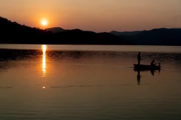 Silhouette of fishing at the sea with mountain and sunset