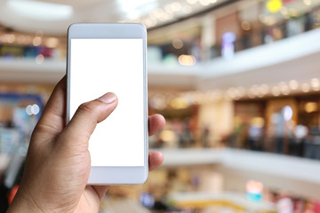 Hand of a man holding smartphone device in the Shopping mall background.
