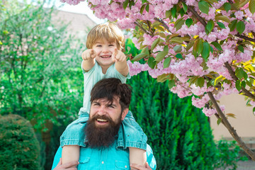 Happy father and son. Two generations ages: father and son piggyback ride together.