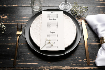 Beautiful table setting with menu on dark wooden background