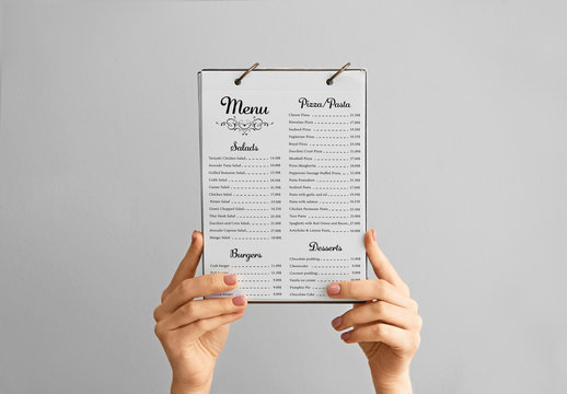 Female hands with menu on grey background
