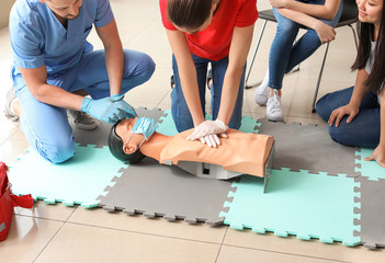 Instructors demonstrating CPR on mannequin at first aid training course