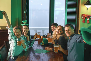 Young friends celebrating St. Patrick's Day in pub