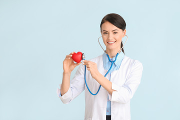 Female cardiologist on color background