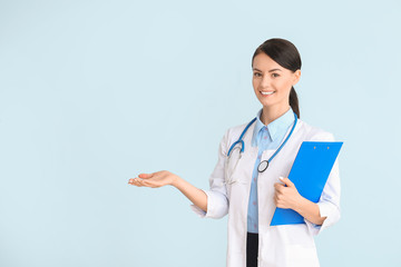 Female cardiologist on color background