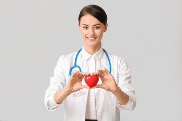 Female cardiologist on light background