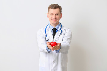 Male cardiologist on light background