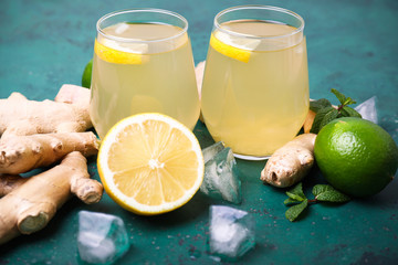 Glasses of healthy drink with citrus fruits and ginger on color background