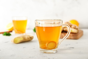 Cup of healthy drink with ginger on white background