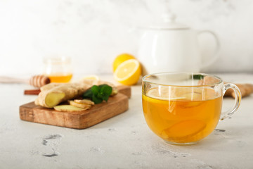 Cup of healthy drink with ginger and lemon on white background