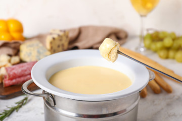 Dipping of crouton into cheese fondue