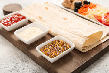 Ingredients for tasty doner kebab and sauces on white background, closeup