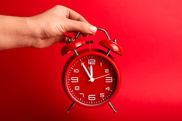 Female hand with alarm clock on color background. Time management concept