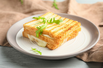 Plate with tasty sandwiches on table