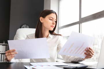 Young female accountant working in office