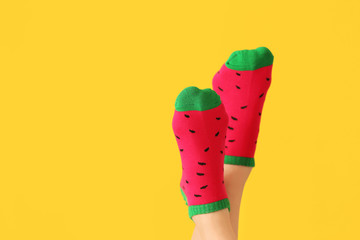 Legs of young woman in socks on color background