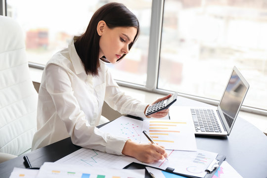 Young female accountant working in office