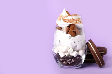 Glass with tasty dessert and cookies on color background