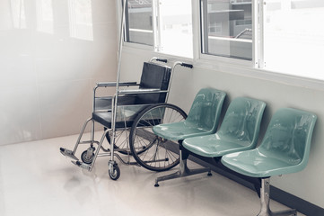 Empty wheelchair and green chairs for patient in the hospital.Medical tool concept.