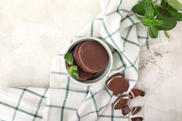 Bowl with tasty cookies and mint on white background