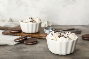 Bowl with tasty cookies on grey table