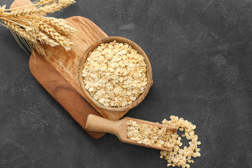 Bowl and scoop with raw oatmeal on table