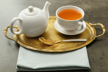 Teapot and cup of hot beverage on table