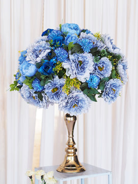 blue flower bouquet on golden vintage vase