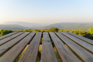 Fototapeta premium Empty wooden table top in front of trees and mountain landscape, For product display or montage your products.