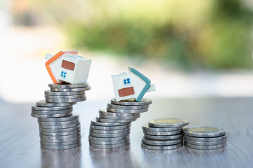 Miniature house models and stacked coins Business risk management Real estate investment and home...
