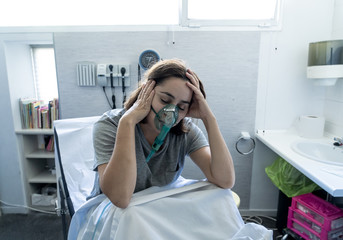 Sick woman with oxygen mask in emergency room at hospital