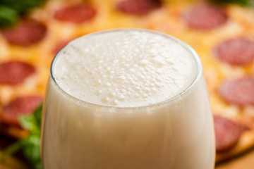 Freshly brewed beer and pepperoni pizza in bar. Selective focus. Shallow depth of field.