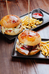 Two mouth-watering, delicious homemade burger used to chop beef. on the wooden table.