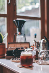 Close up glass of ice americano coffee on wood table.a cup of ice coffee in morning on a wooden table in a coffee cafe bar.Drinking americano coffee in relaxing chilling lonely feeling. waiting someon