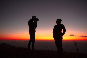 Fototapeta na wymiar 23.10.2019 Friend Group hiking Doi Monjong, Chiang Mai, Thailand., Sunset Silhouette of Young Lovers Hugging in the Mountains., Photos with high shadows and selectable focus