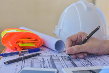 Close up hand writing on paperwork blueprint inspection plan construction architecture project...