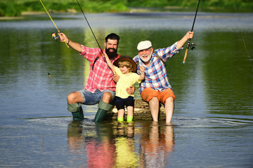 Happy Grandfather with son and grandson having fun in river. Men day. Father, son and grandfather...