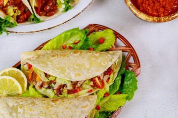 Mexican food flour tortilla stuffed with lettuce, meat and cheese.